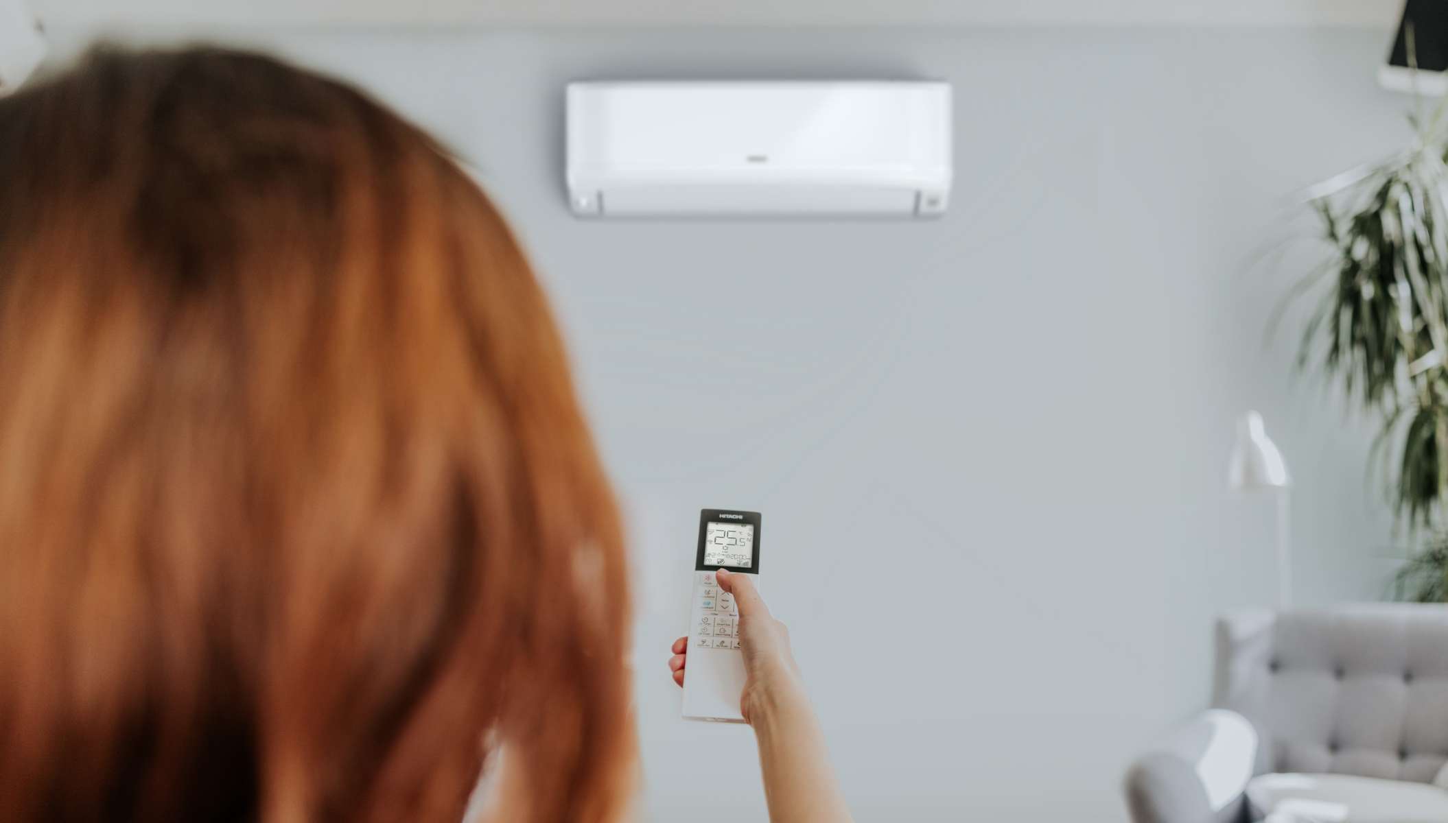 Woman Using Smart Remote for AC Unit